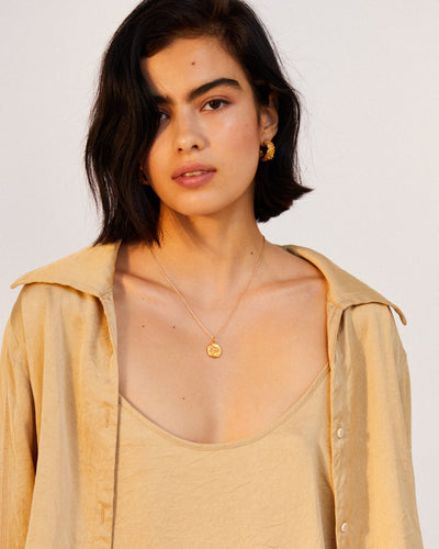 model wearing Alighieri Gold Aries Zodiac Necklace Medallion